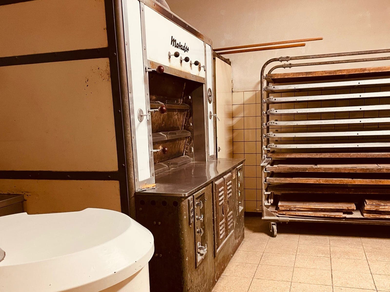 Werkstatt der Bäckerei Schwehr — der historische Matador-Ofen und der Brotwagen mit Backblechen